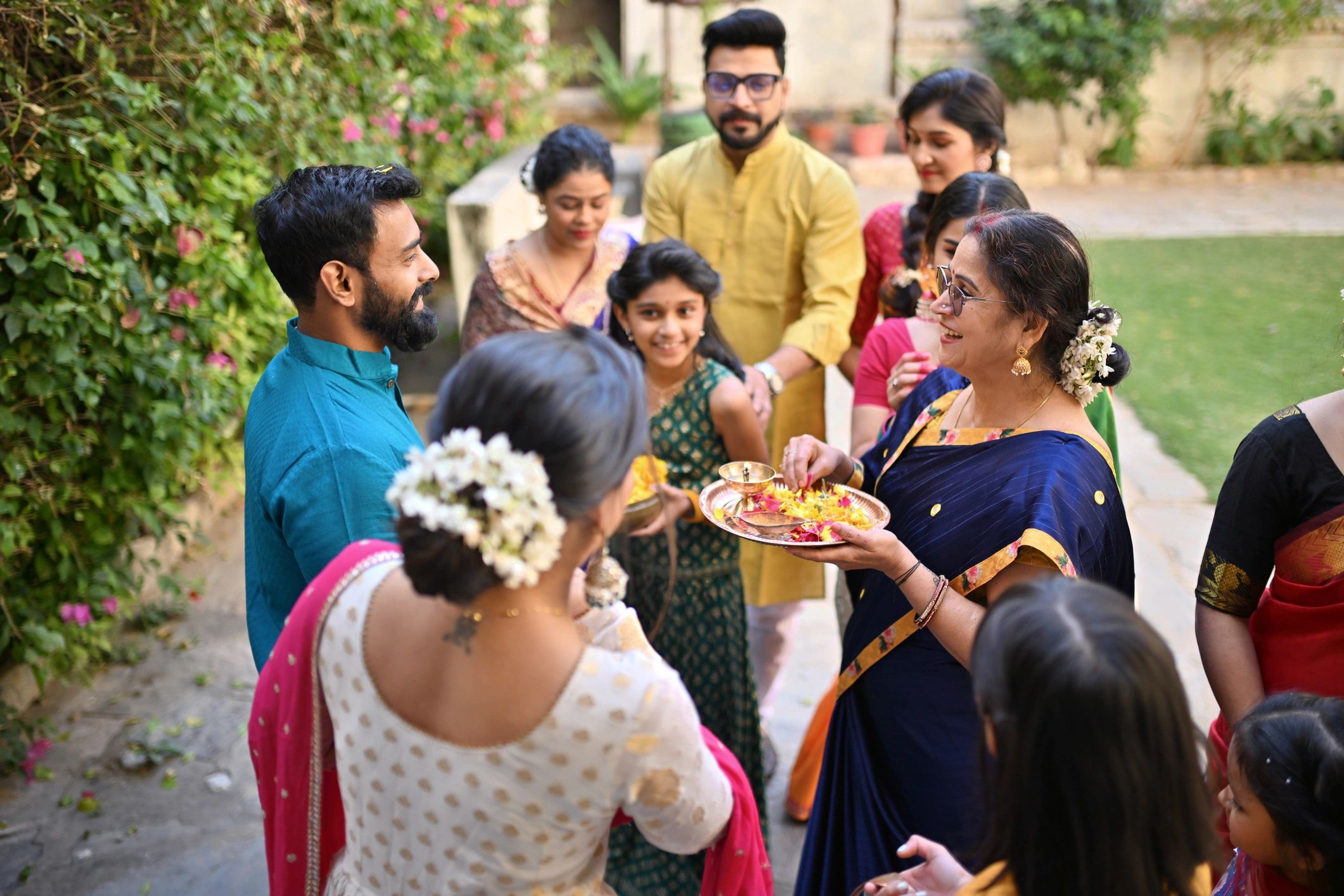 Family welcoming guests during an Indian wedding celebration